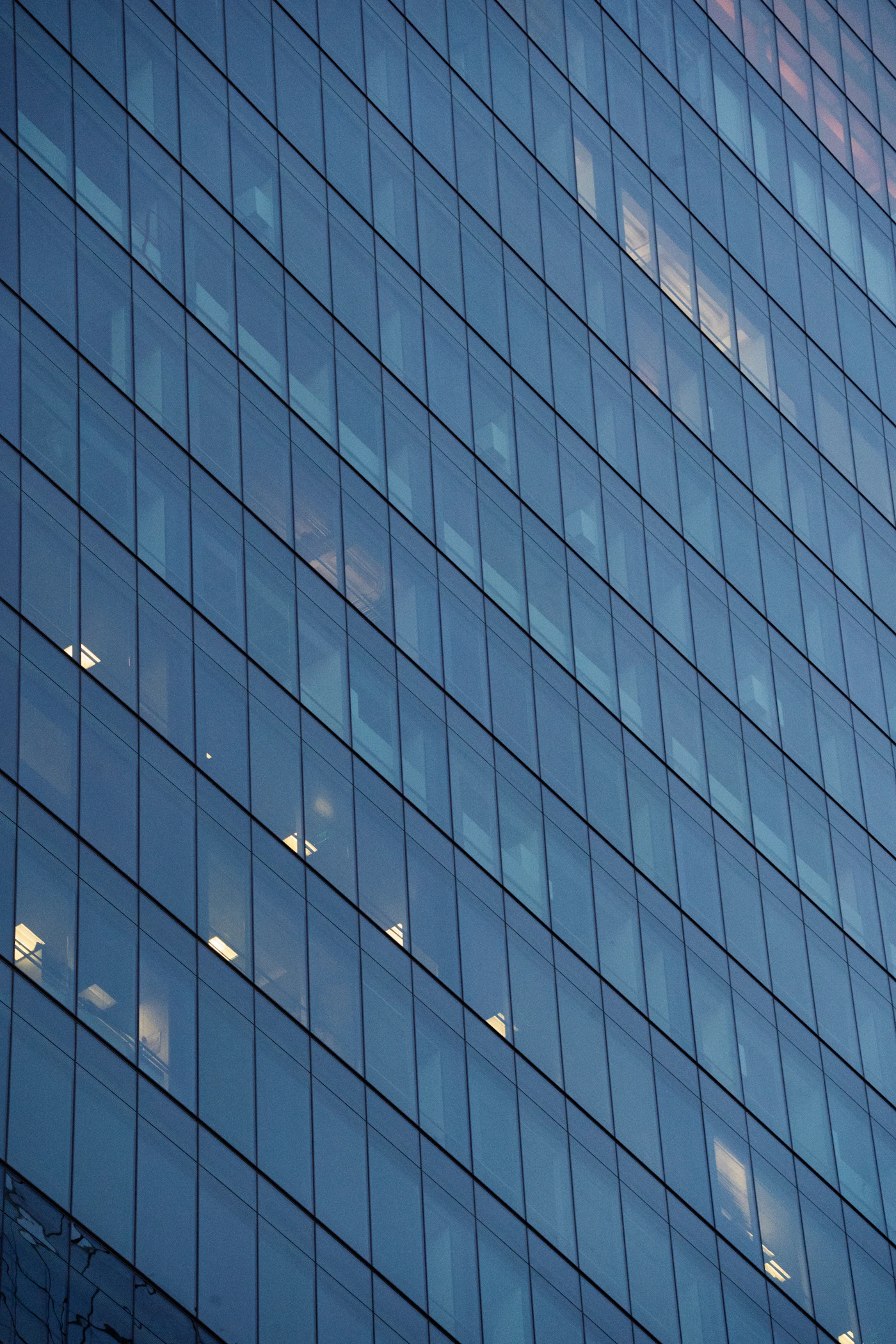 Modern glass office facade reflecting the sky